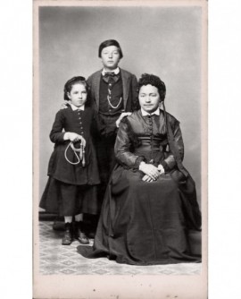 Mère assise avec deux enfants debout