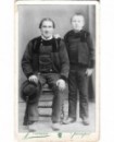 Père assis et fils debout, en costume breton