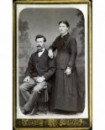 Homme à moustache assis et femme debout