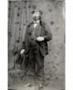 Homme à moustache et barbe chapeau sur la tête tenant sa montre
