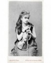 Femme (maquillée) assise tenant un violon