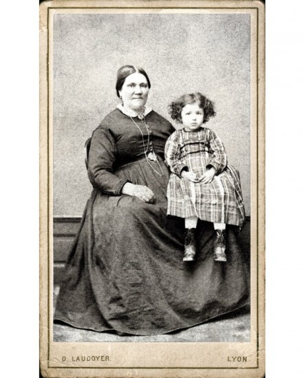 Femme forte assise, enfant en robe sur les genoux