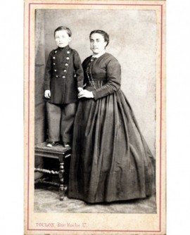 Jeune femme debout, tenant son fils debout sur une chaise