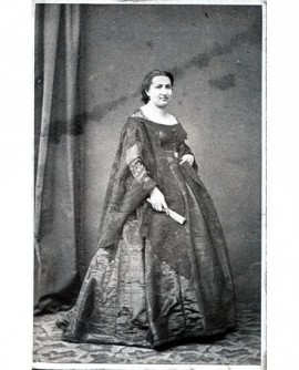 Femme debout en robe tenant un éventail