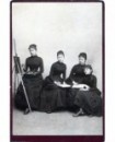Quatre femmes posant en robe noire, une peintre