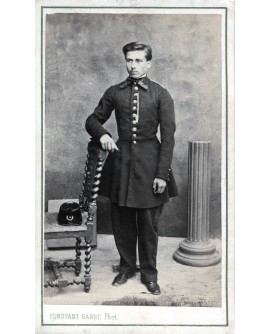 Jeune homme en uniforme, képi sur une chaise