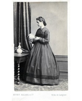 Femme debout en robe regardant une poterie