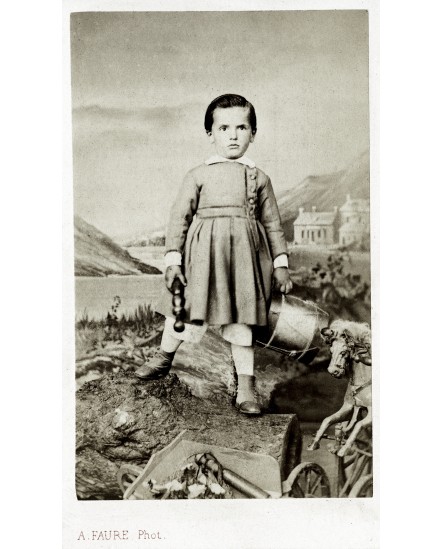 Jeune garçon tenant un tambour et une quille. jouet