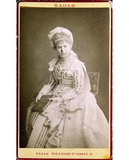 Jeune femme en chapeau assise, un livre à la main