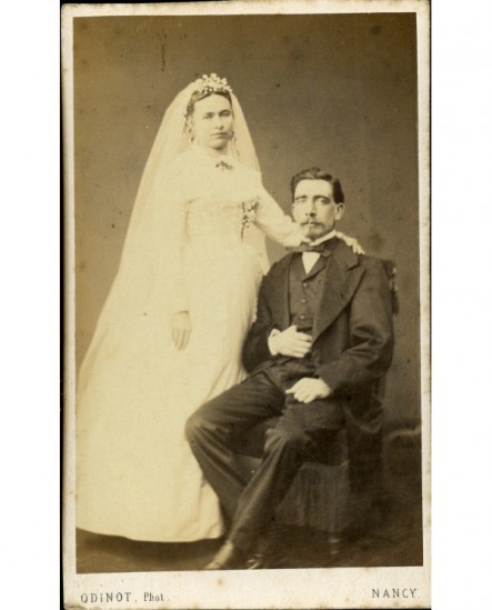Couple de mariés: homme assis, femme debout la main sur son épaule