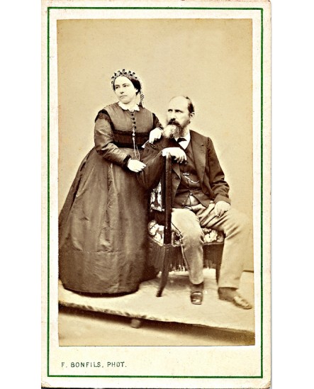 Couple: homme barbu assis et femme en bonnet debout