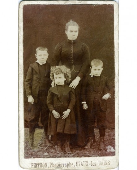 Femme en robe noire avec trois enfants